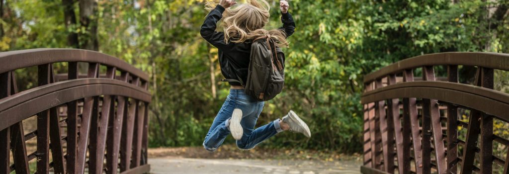 girl-jumping-on-the-bridge-wearing-black-jacket-214573